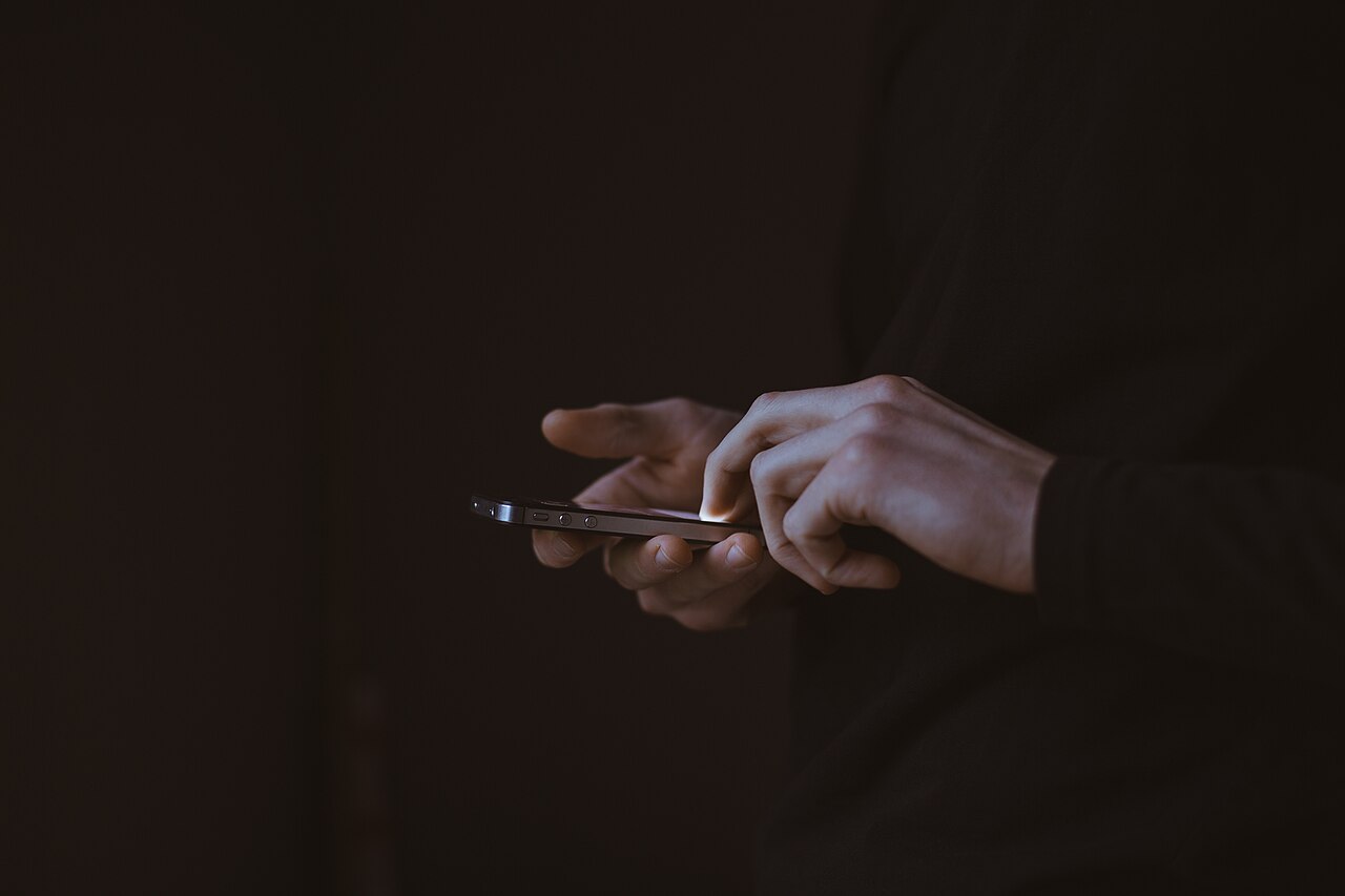 屋外でスマートフォンを操作する人物