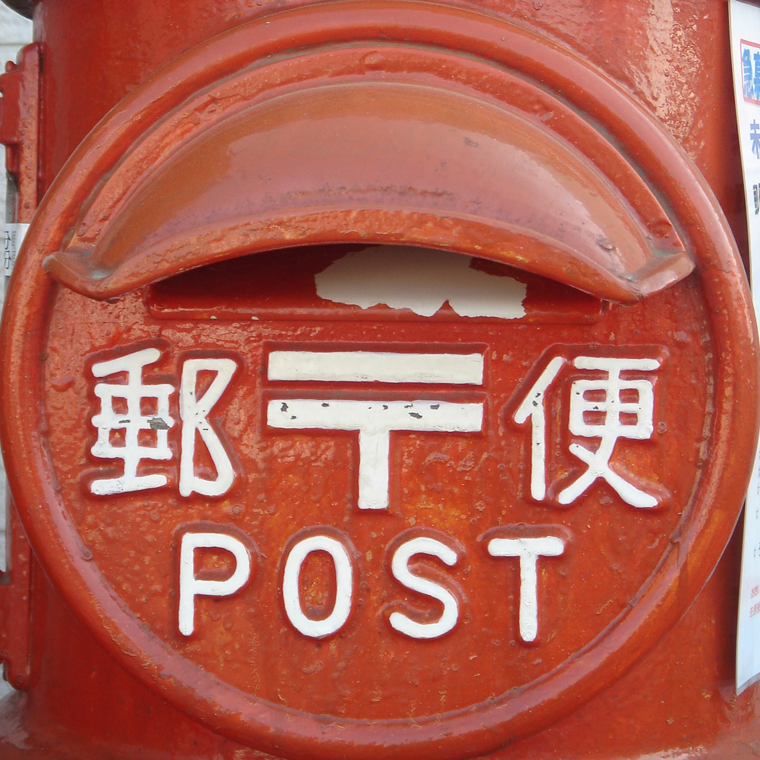 記入したはがきを投函する赤い郵便ポスト