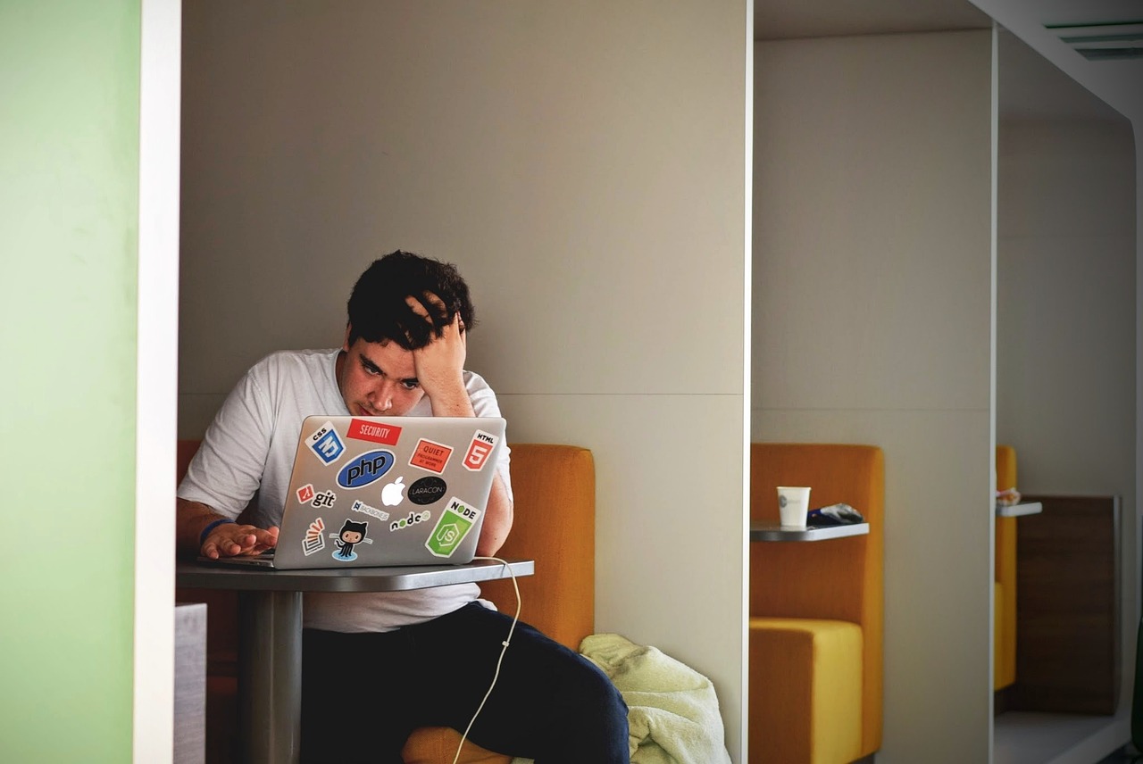 ノートPCの前で数式が計算されず頭を抱える男性