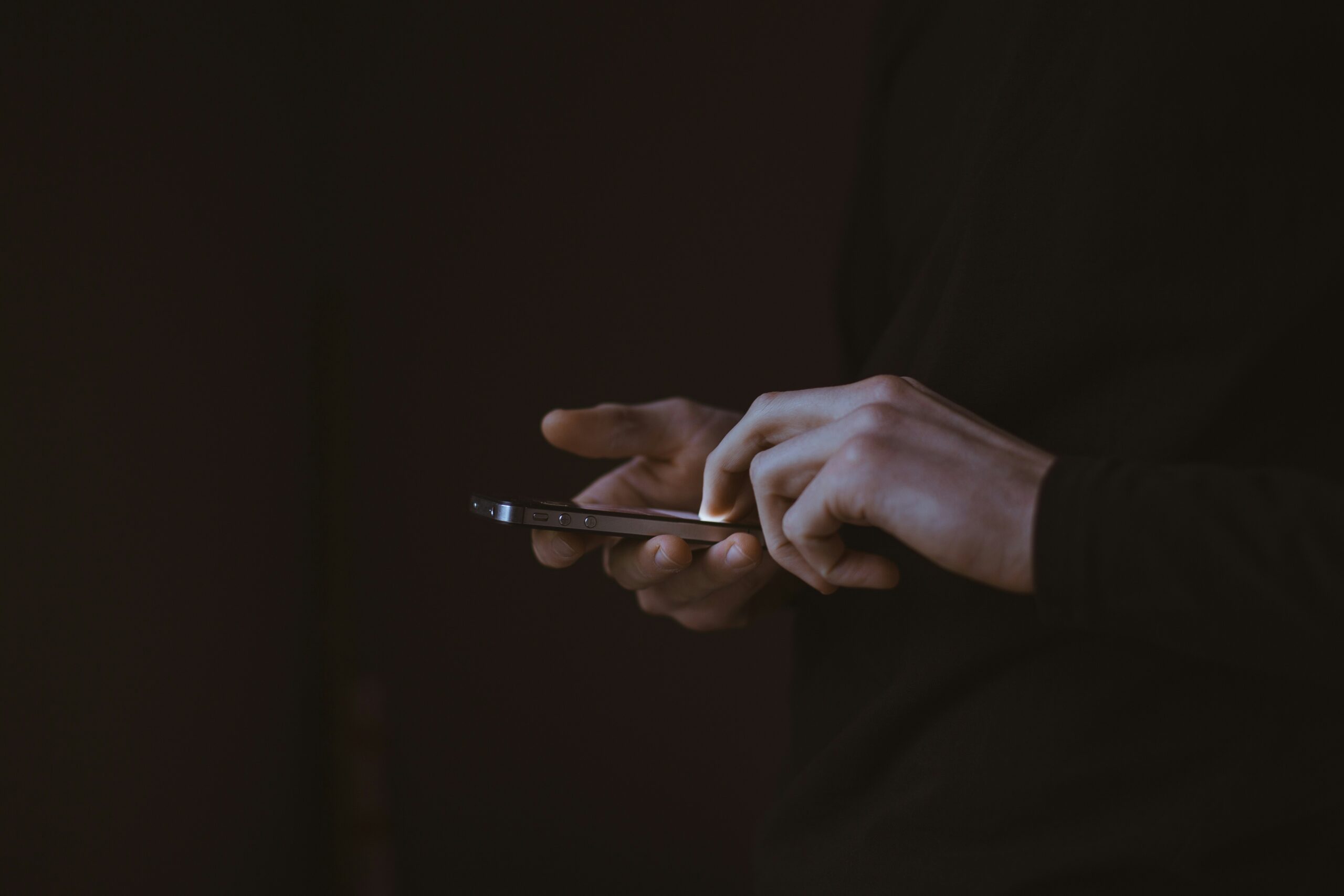スマートフォンを操作する人物のシルエット