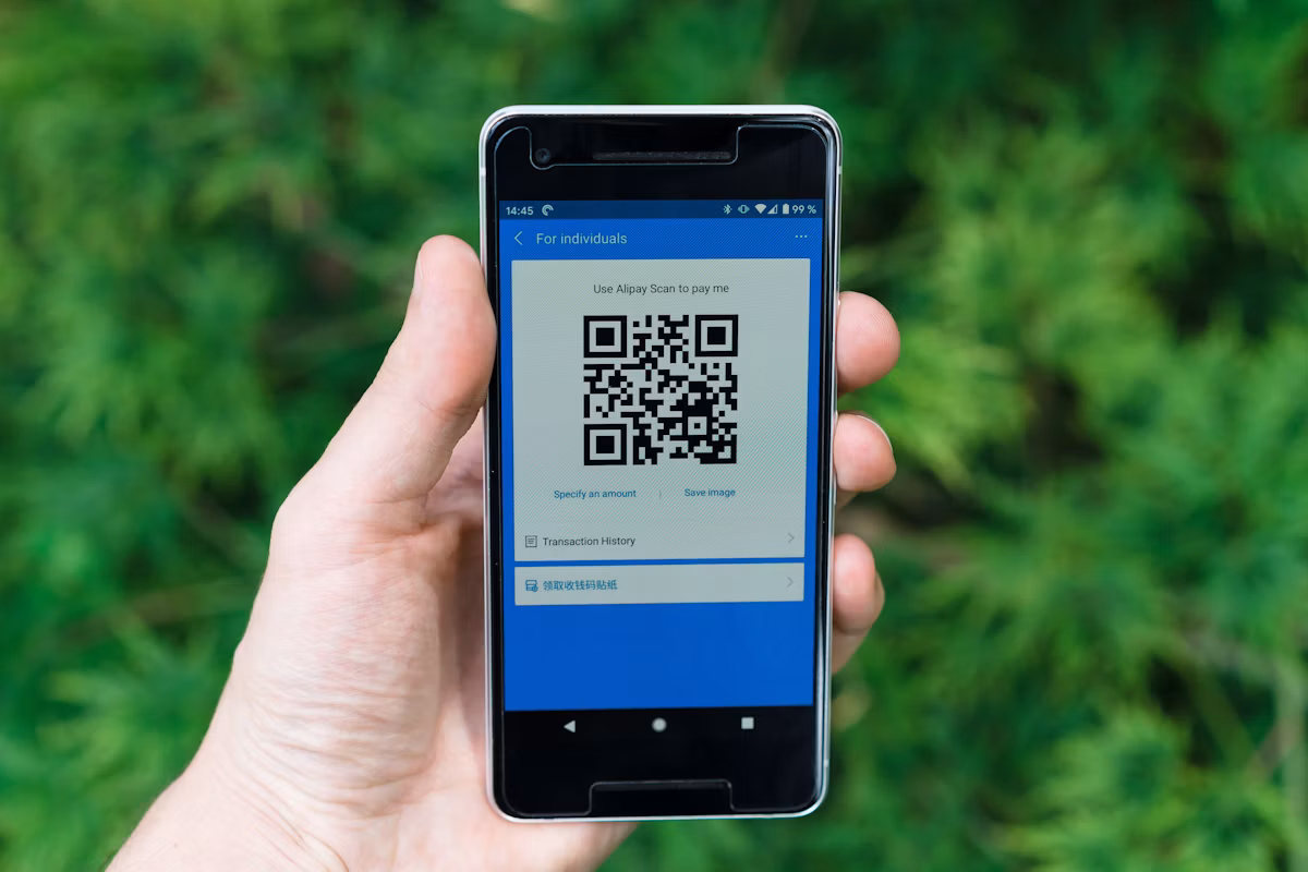 スマートフォンにQRコード決済の画面を表示してレジで支払う様子