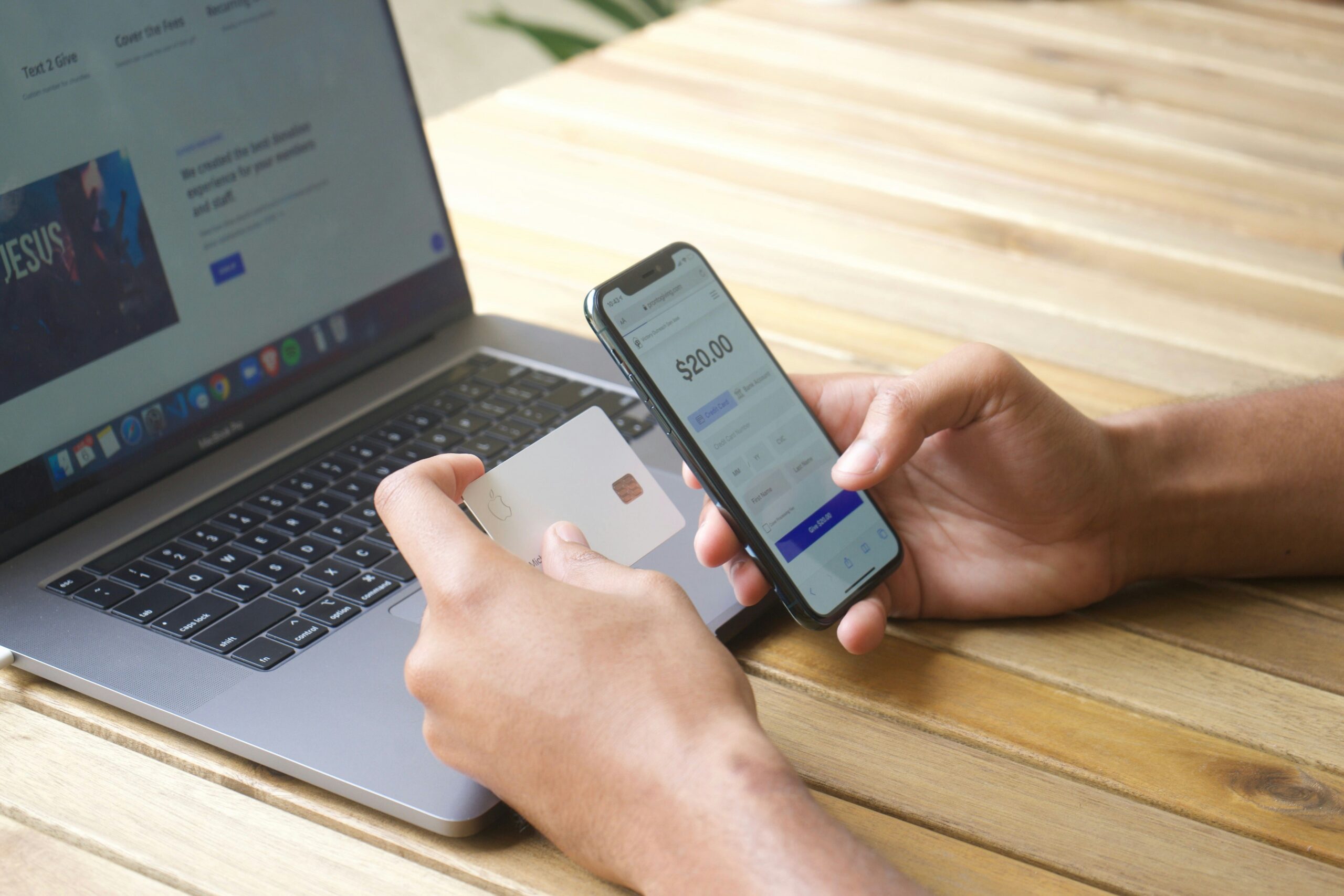 スマートフォンとパソコンでクレジットカード情報を入力しオンライン決済をしている手元