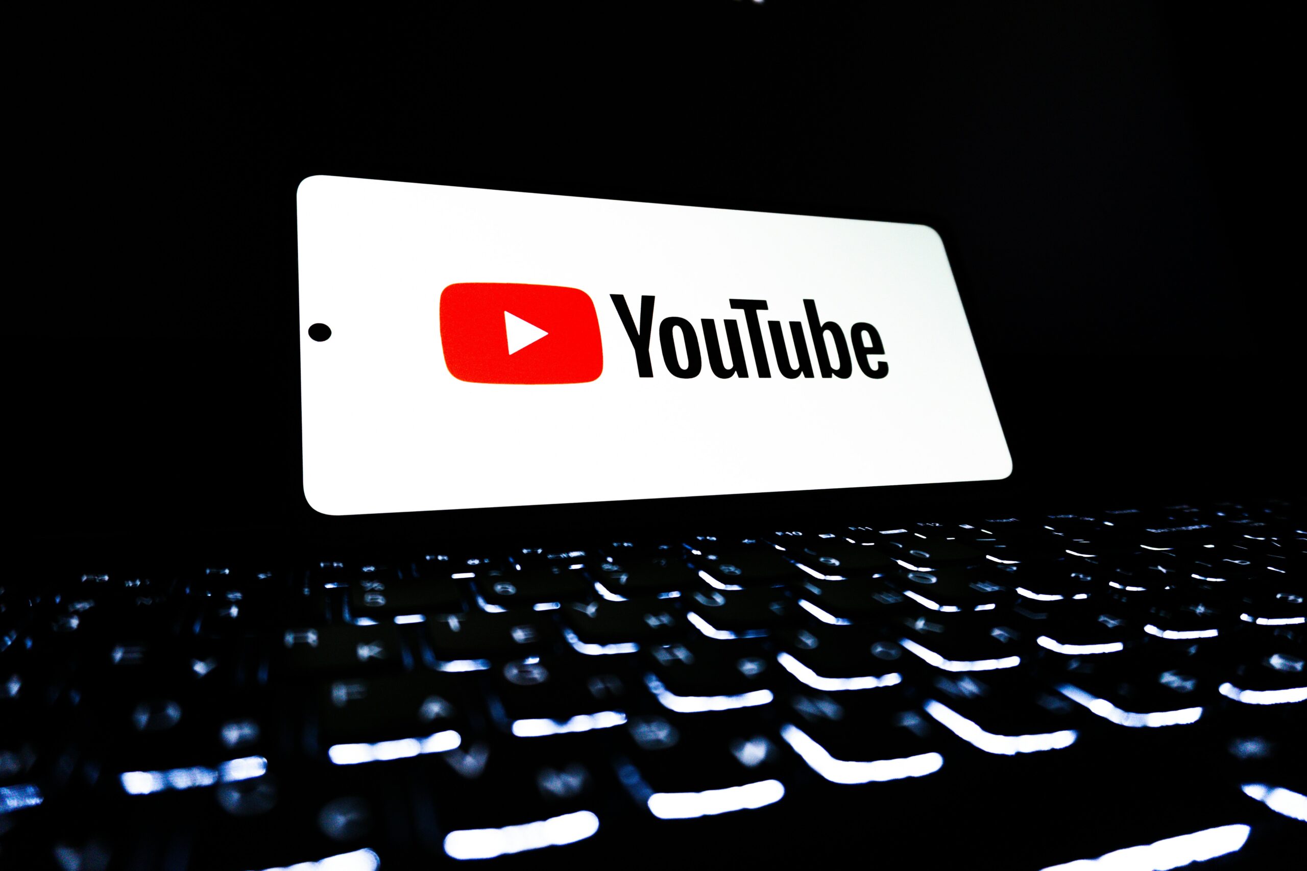 YouTubeのロゴが表示されたスマートフォンとキーボード