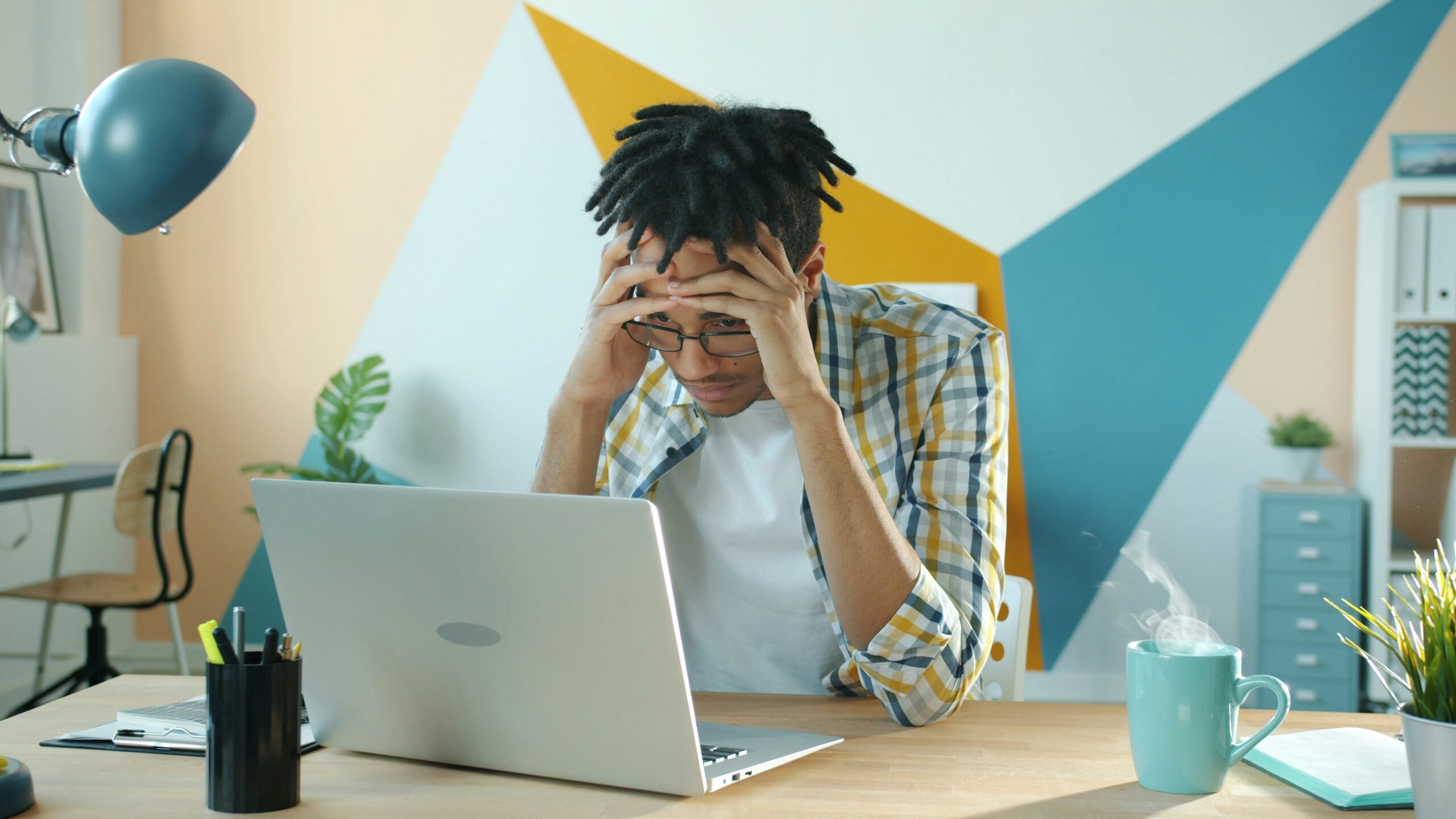 ノートPCの前で頭を抱える男性