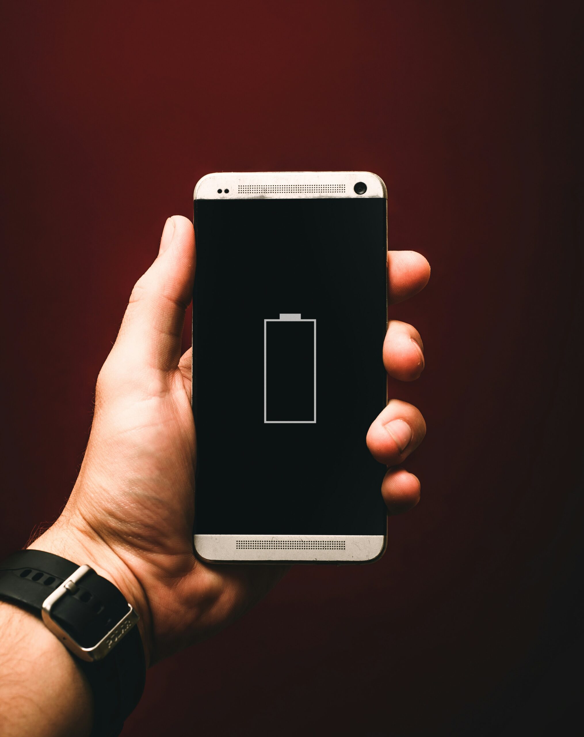 バッテリー残量が少ないスマートフォンを持つ手