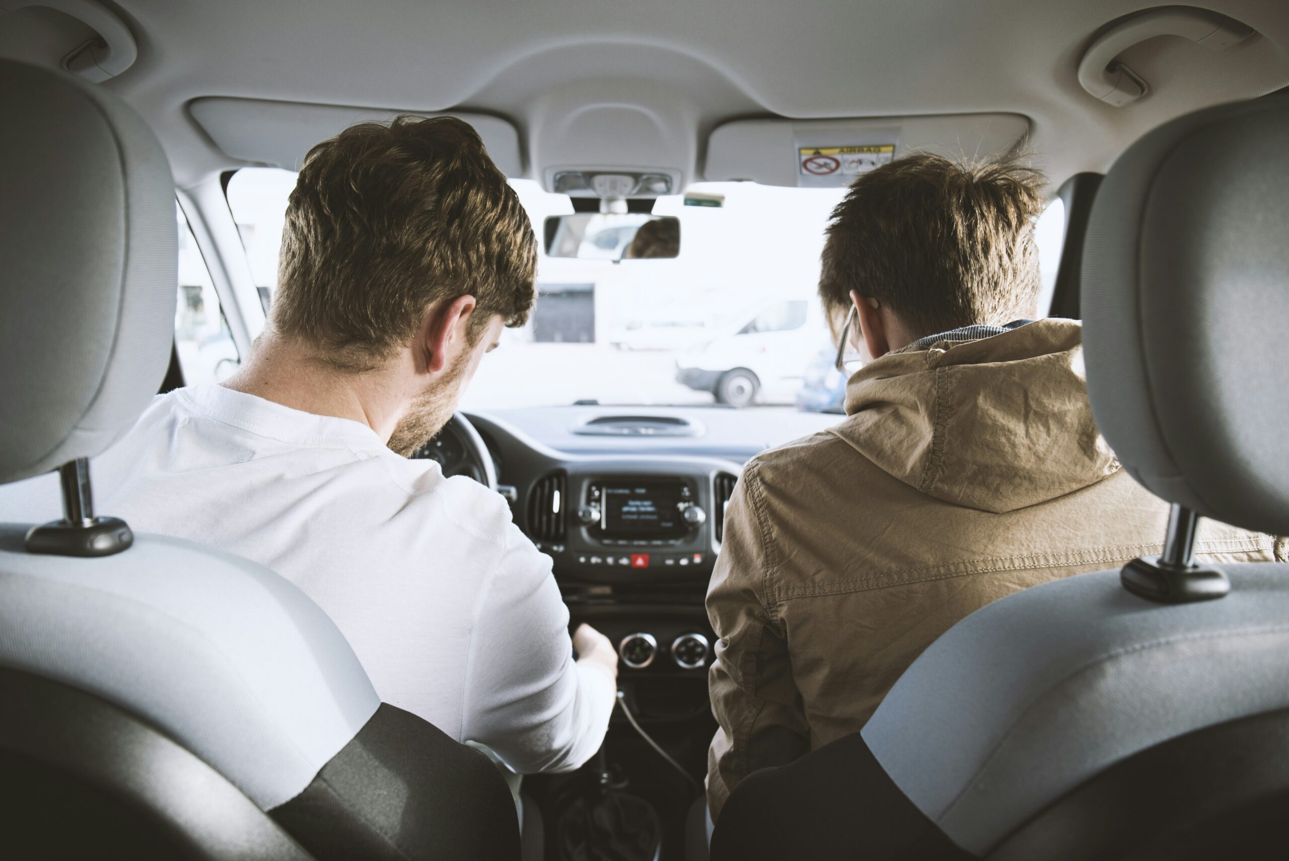 車内に並んで座る2人(出典: Unsplash)