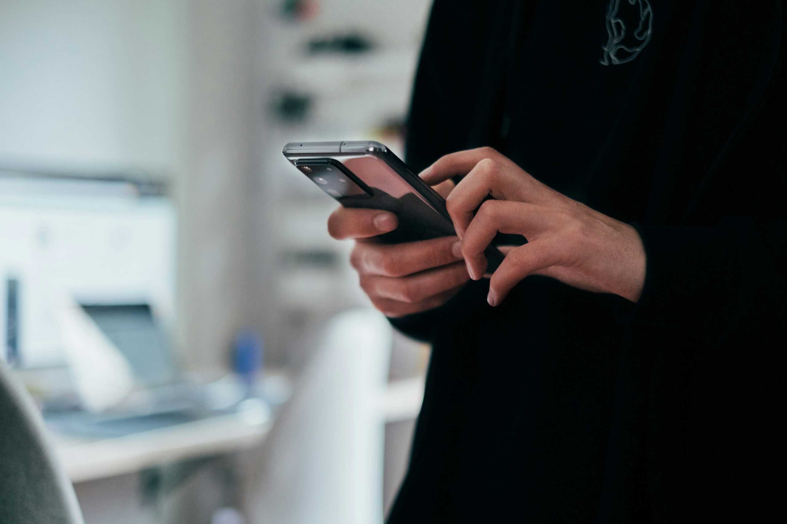 スマートフォンを操作してログインしようとしている手元