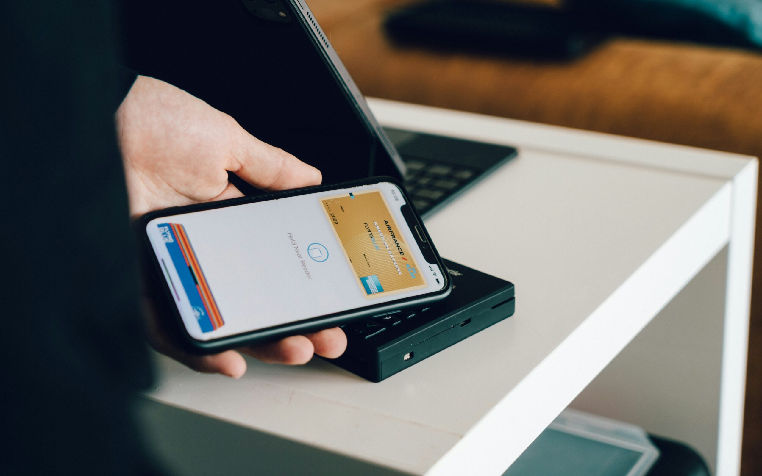スマートフォンでカードリーダーにタッチ決済する様子