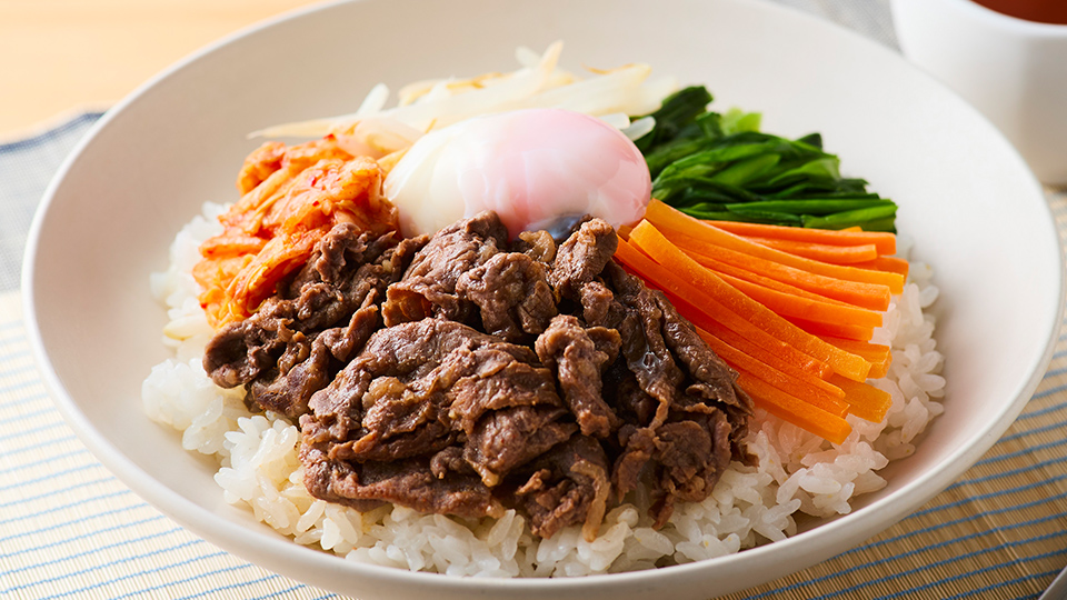 KN-HW24Kで作れる料理例。肉・野菜・キムチ・温泉卵を盛り付けた一皿