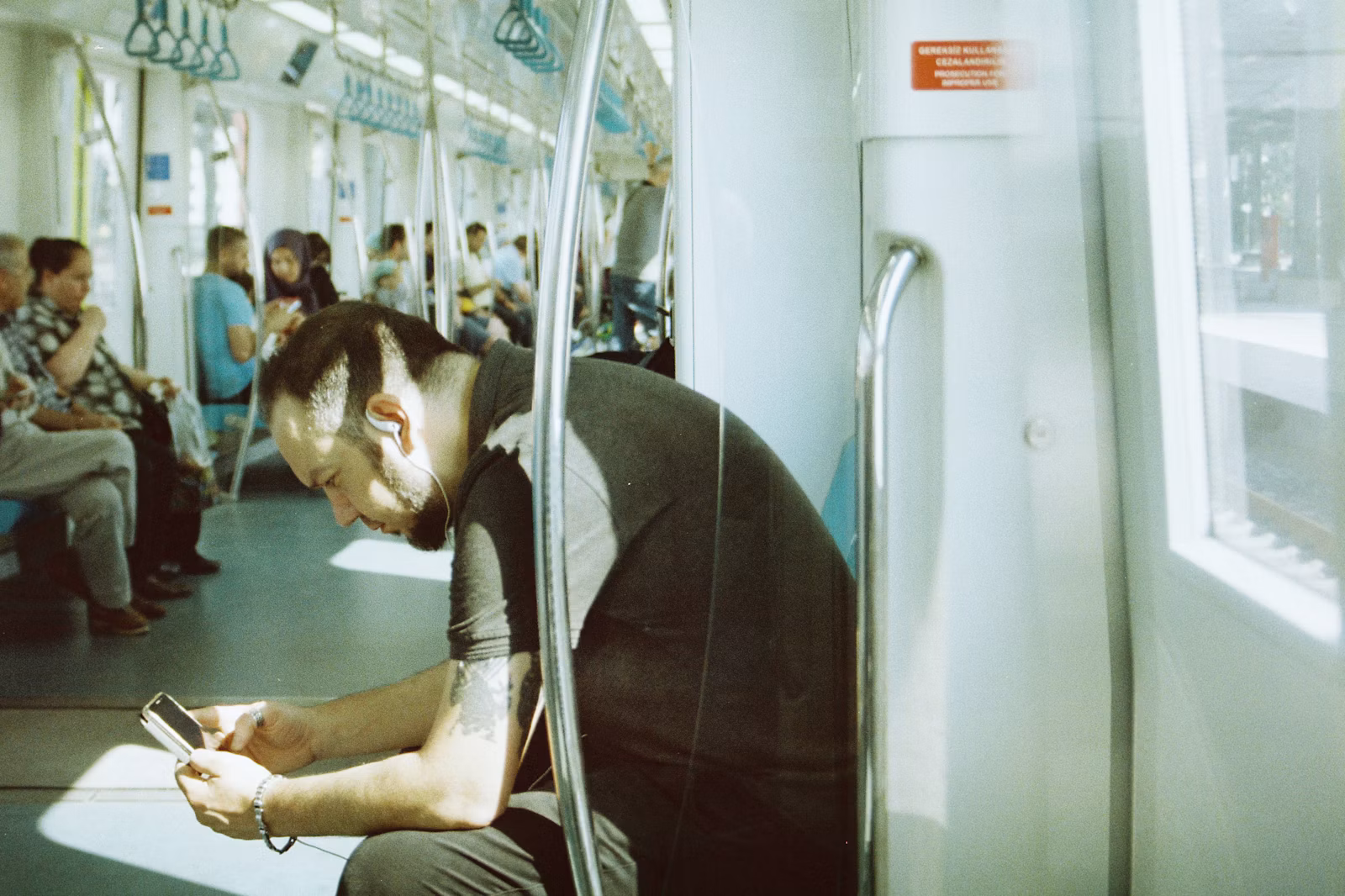 満員電車でスマートフォンを操作する通勤者